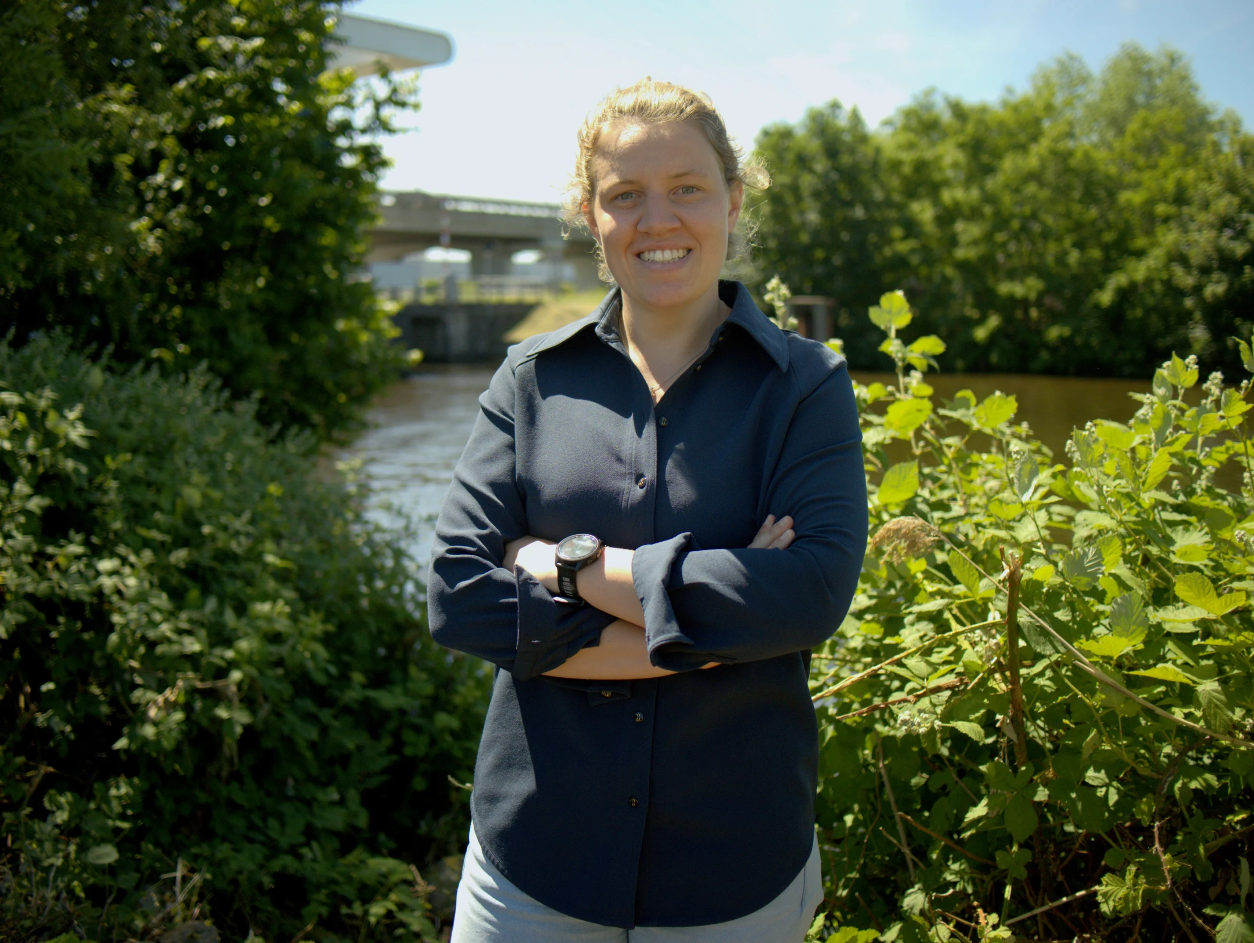 Benthe de Haan voor het kantoor van DEKC, brug en water op de achtergrond
