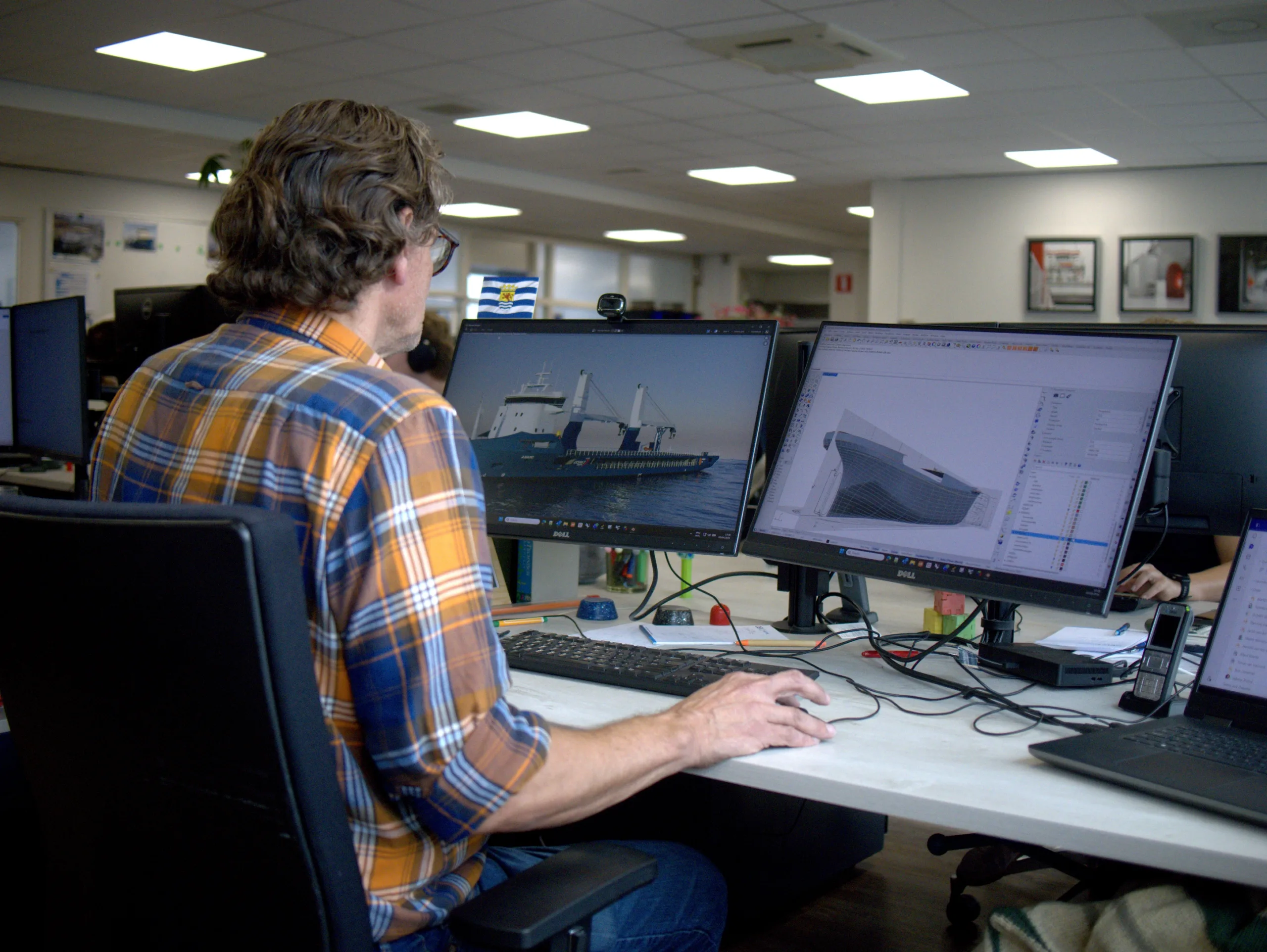 Nico de Meester at his workstation with render and 3D hull model